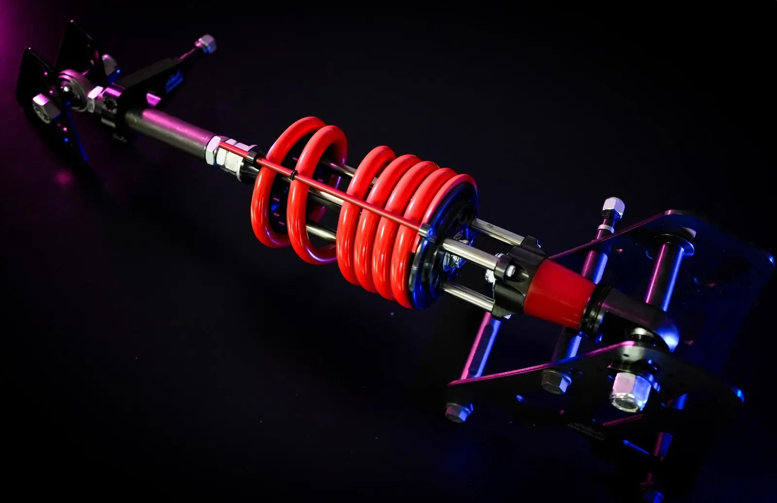 High-performance coilover suspension assembly with red spring and blue anodized adjustable components