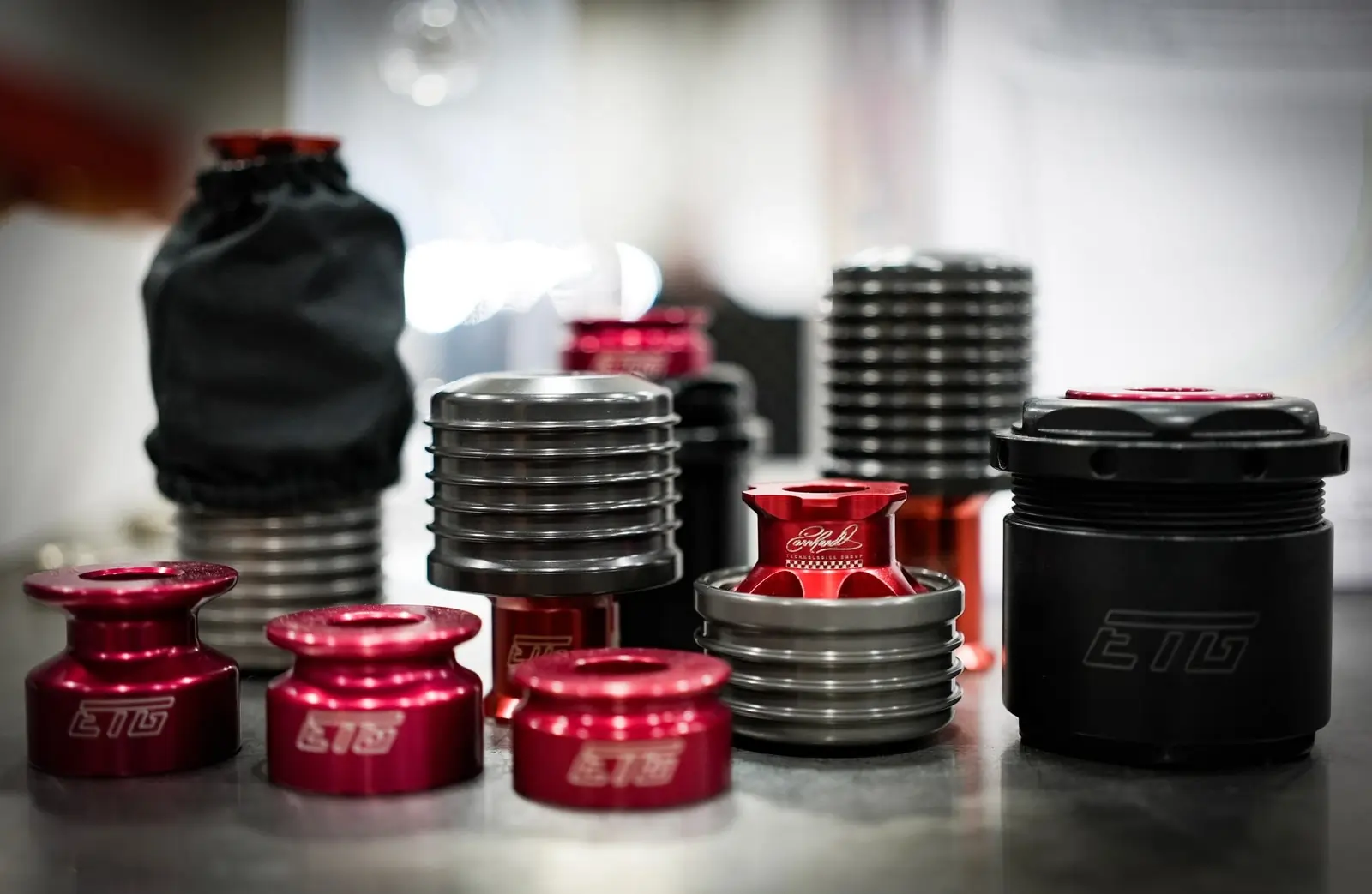 ETG racing setup tools including red anodized spacers and black coilover adjustment components