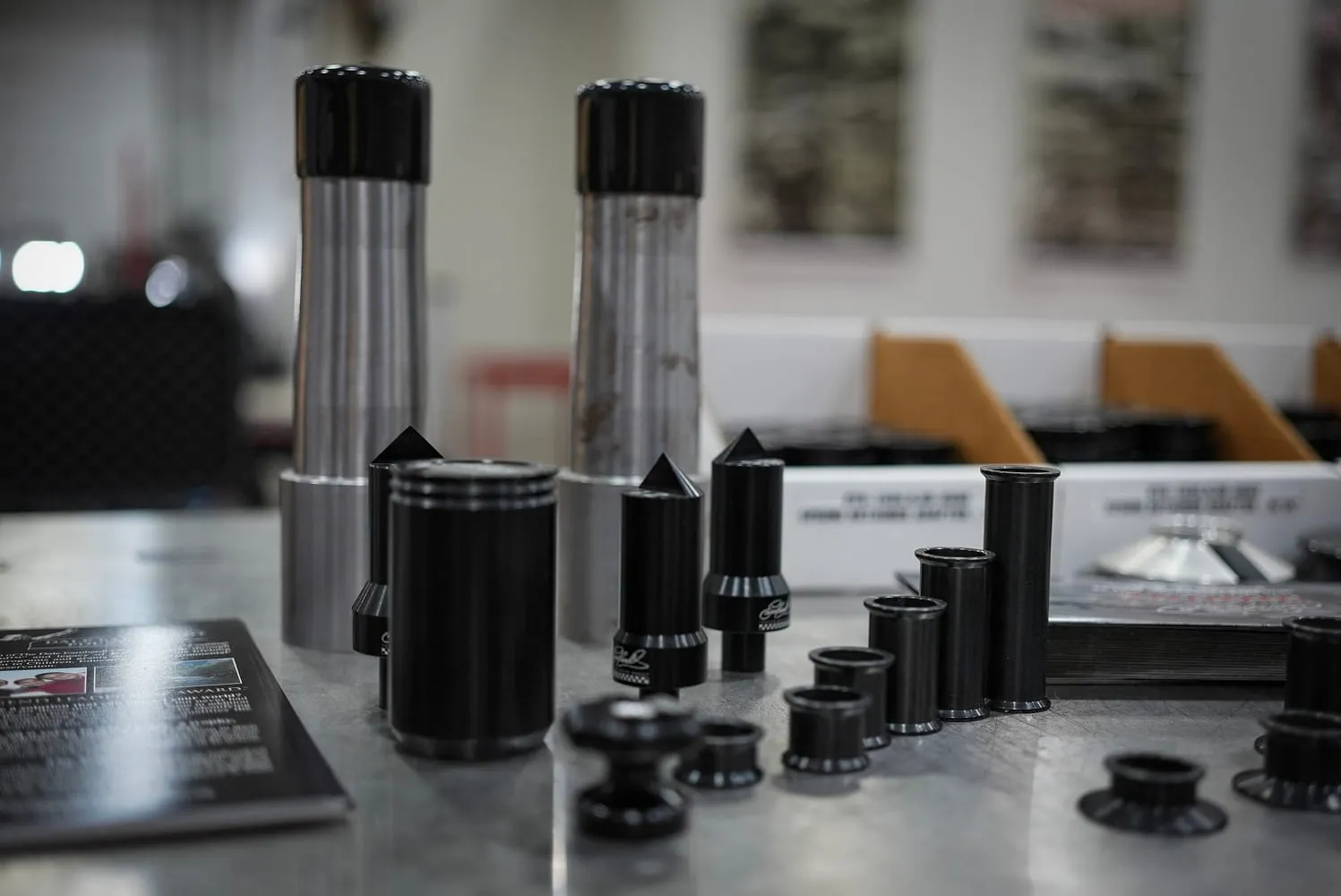 Assorted black anodized ETG bushings, spacers, and bump stops on assembly workbench