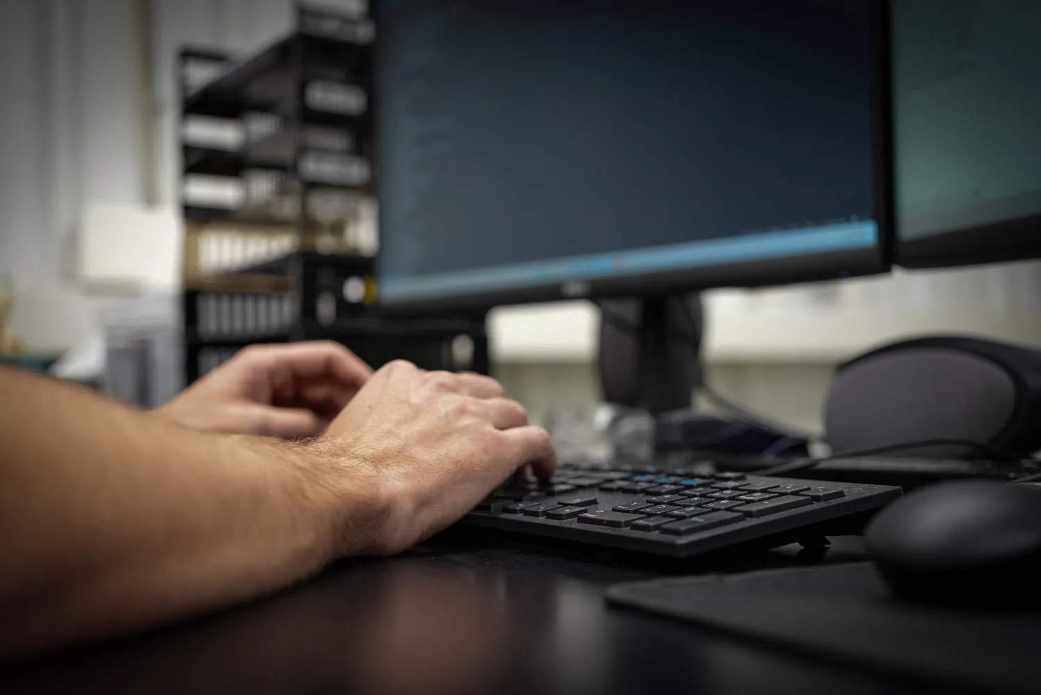 ETG engineer programming CAD software for fixture design at workstation