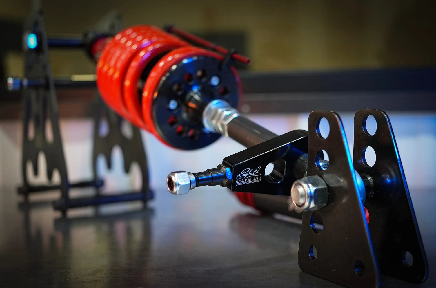 CNC-machined suspension control arm with red anodized spherical bearings and ETG branding