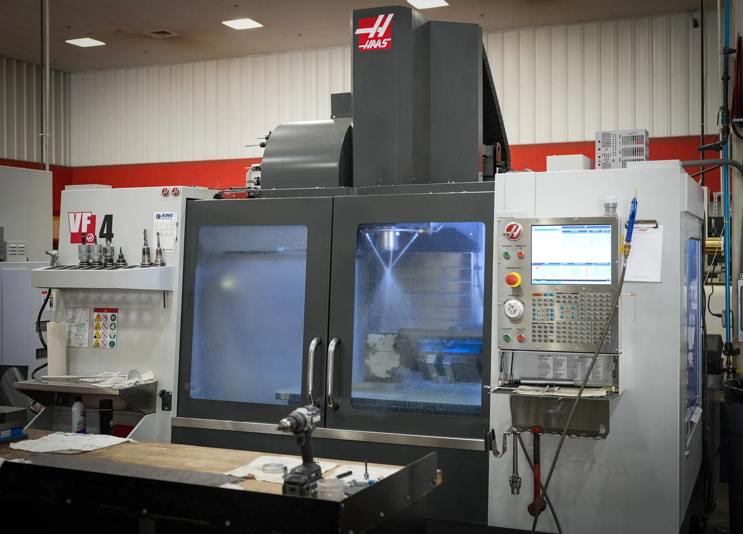 Haas VF-4 CNC vertical machining center with coolant spray during operation at ETG facility