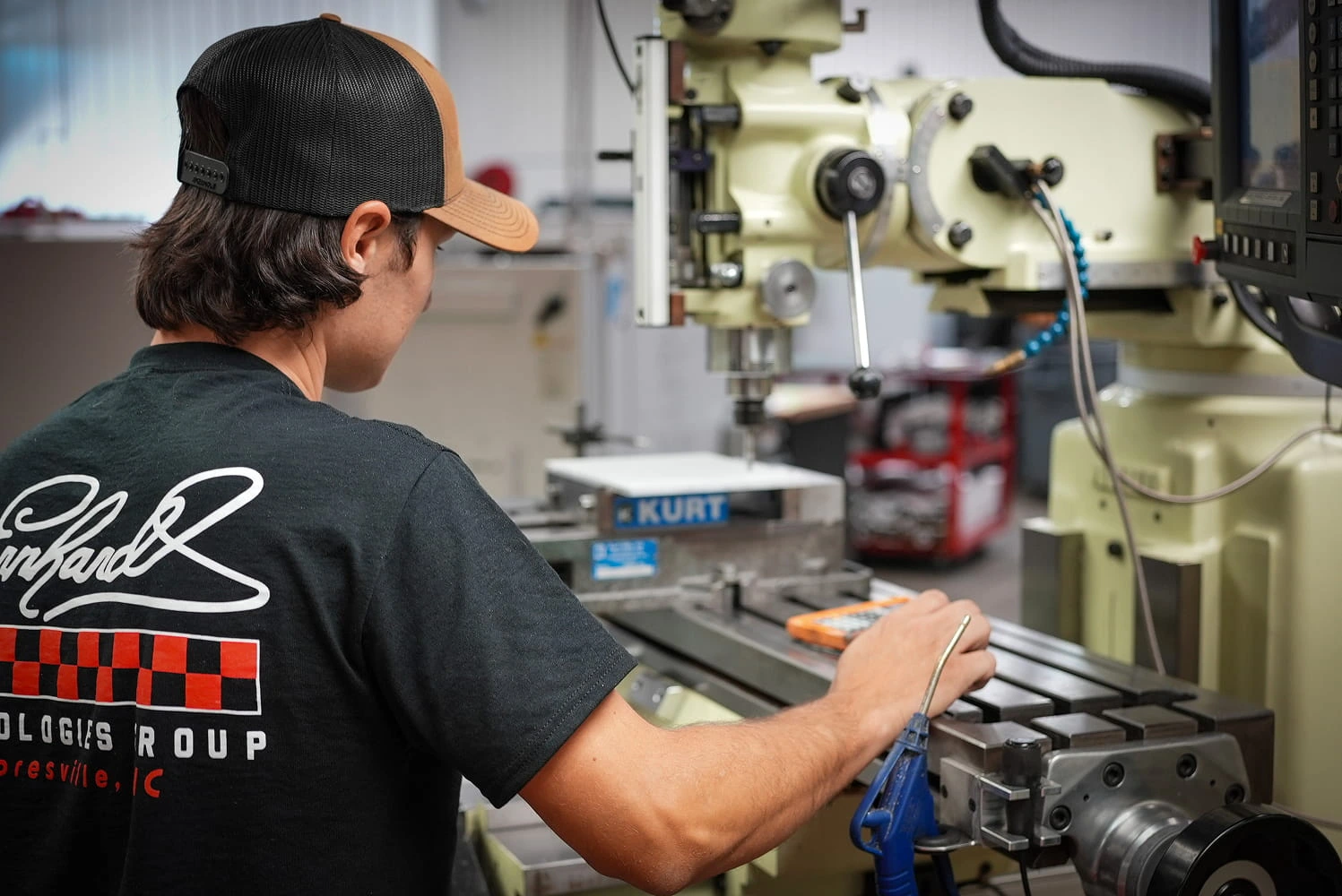 ETG machinist operating a manual milling machine with Kurt vise in the Mooresville facility