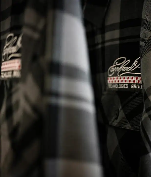 Black ETG Racing hoodie with embroidered logo displayed against a dark workshop background