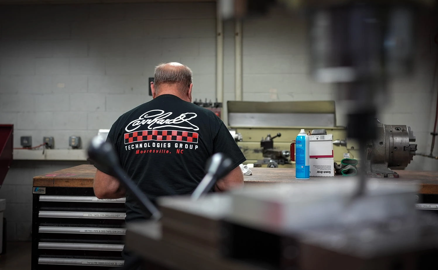 Experienced ETG machinist working at lathe station in the Mooresville machine shop