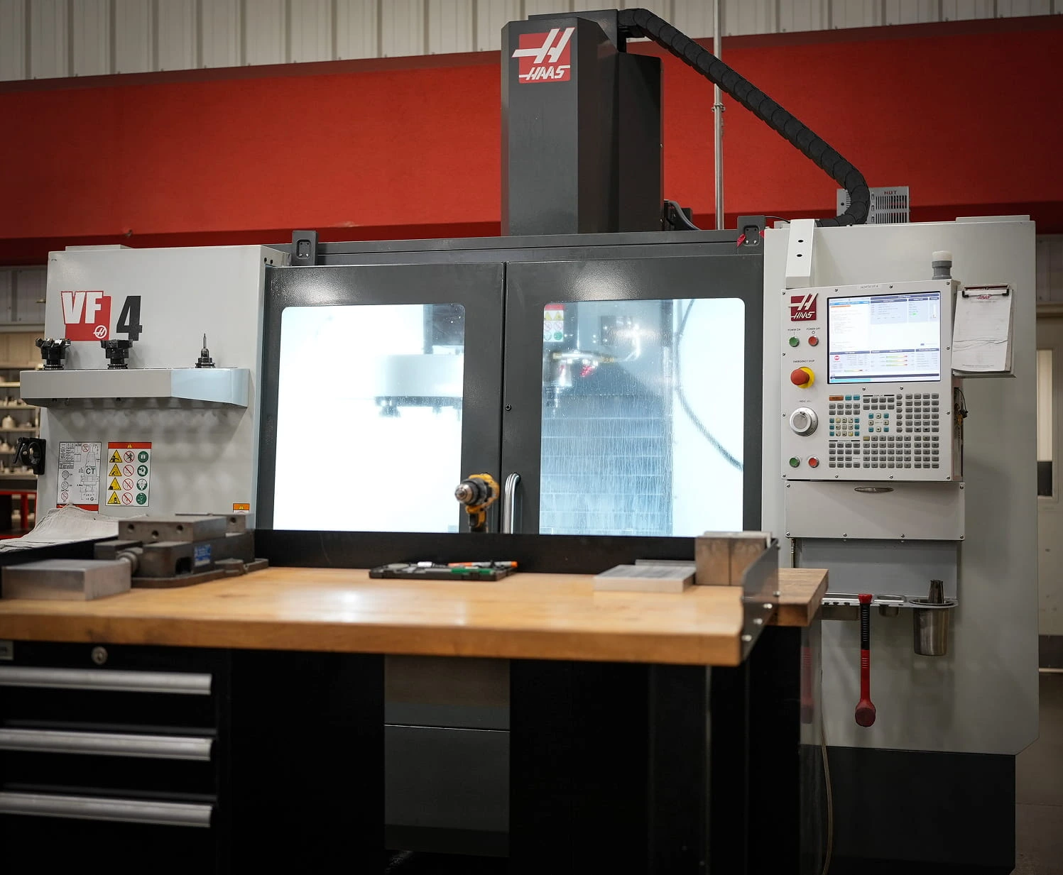 Haas VF-4 vertical machining center with control panel and workbench at ETG facility