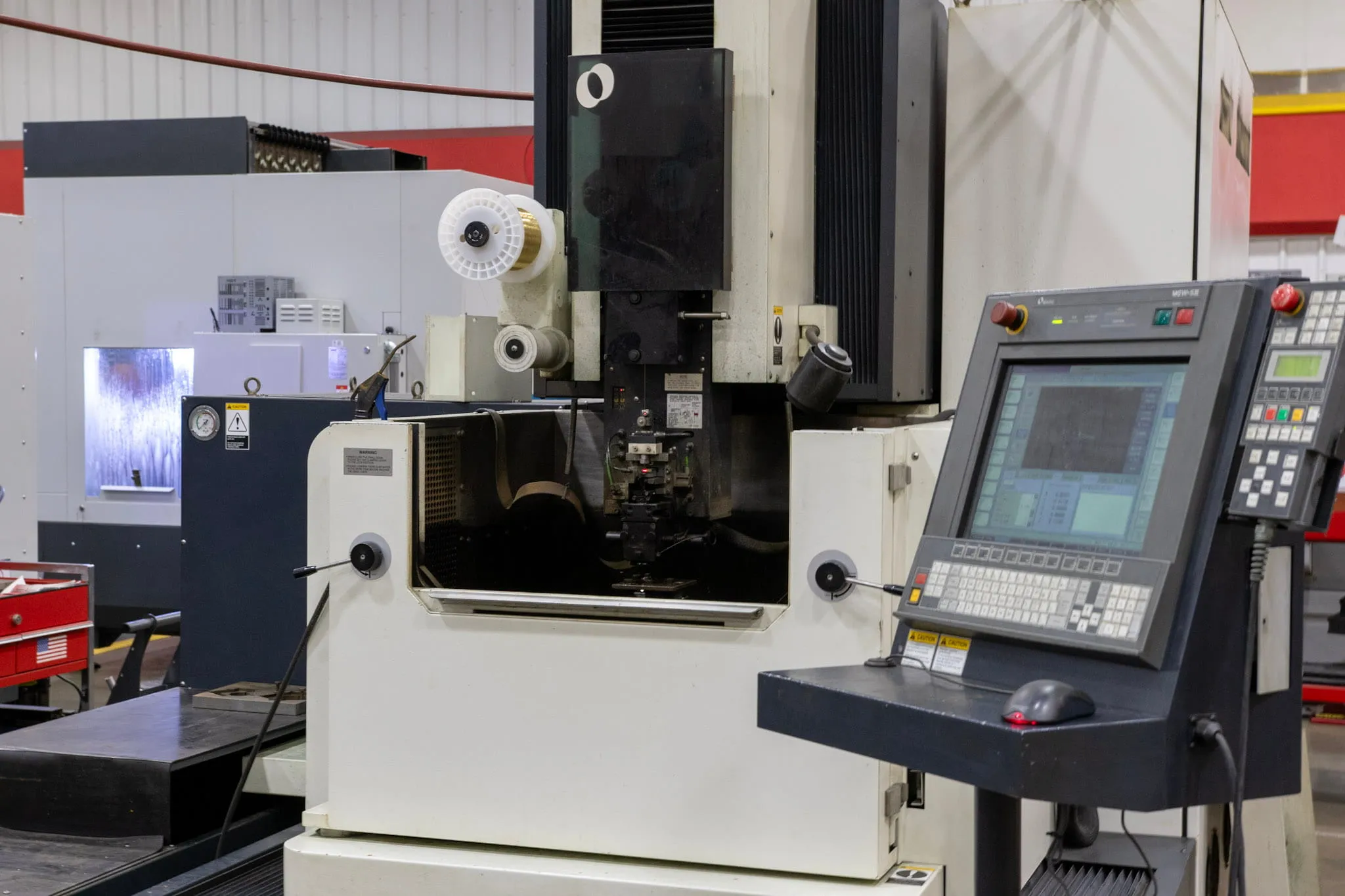 Makino SP43 wire EDM machine with control panel and wire spool for high-tolerance cutting